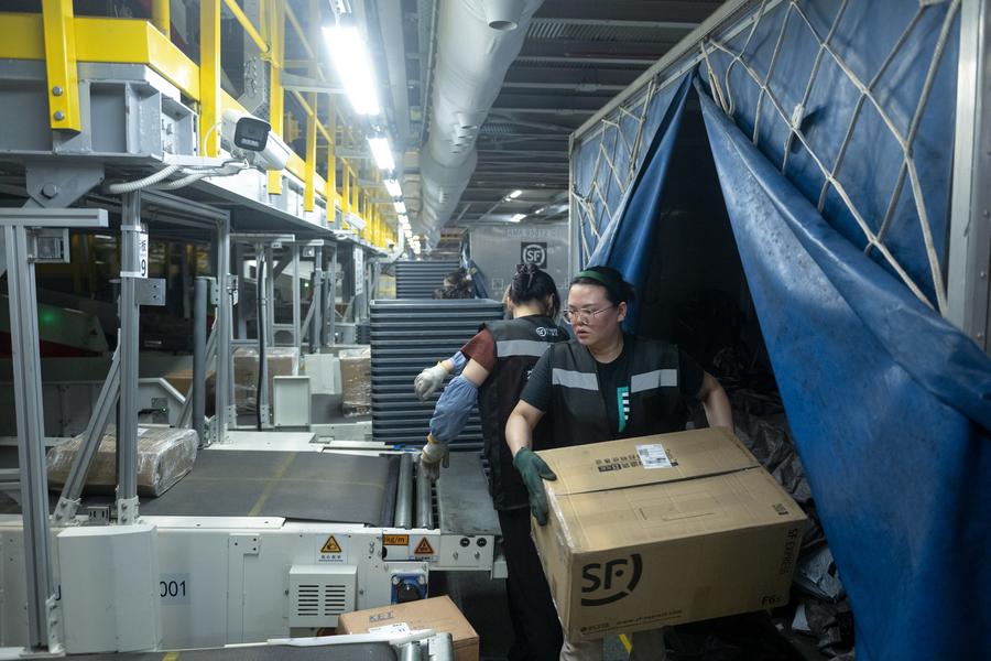 Des employées trient des colis au centre de distribution de l'aéroport Huahu d'Ezhou, à Ezhou, dans la province chinoise du Hubei (centre), le 25 mai 2024. (Photo : Xiao Yijiu)