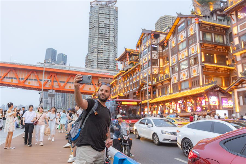 Un touriste pakistanais prend un selfie dans la zone touristique de Hongyadong de l'arrondissement de Yuzhong, à Chongqing, dans le sud-ouest de la Chine, le 8 juillet 2024. (Photo : Huang Wei)