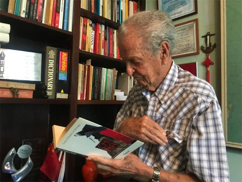 Carlos Tavares passe en revue les livres qu'il a écrits sur la Chine chez lui à Rio de Janeiro, au Brésil, en octobre 2019. (Photo / Xinhua)