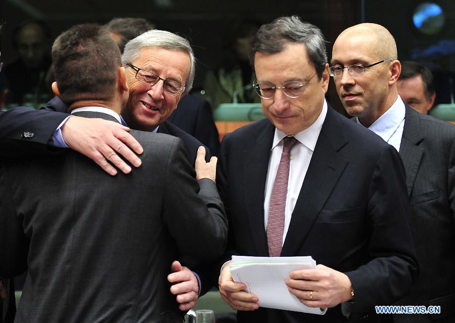 Le Premier ministre du Luxembourg et président de l'Eurogroupe Jean-Claude Juncker (2e à gauche) embrasse le ministre grec des Finances Yannis Stournaras (1er à gauche) à c?té du président de la Banque centrale européenne Mario Draghi (2e à droite) avant une réunion de l'Eurogroupe au siège de l'UE, à Bruxelles, capitale de la Belgique, le 12 novembre 2012. Les ministres des Finances de la zone euro se sont réunis lundi pour discuter de la situation de la dette en Grèce. 