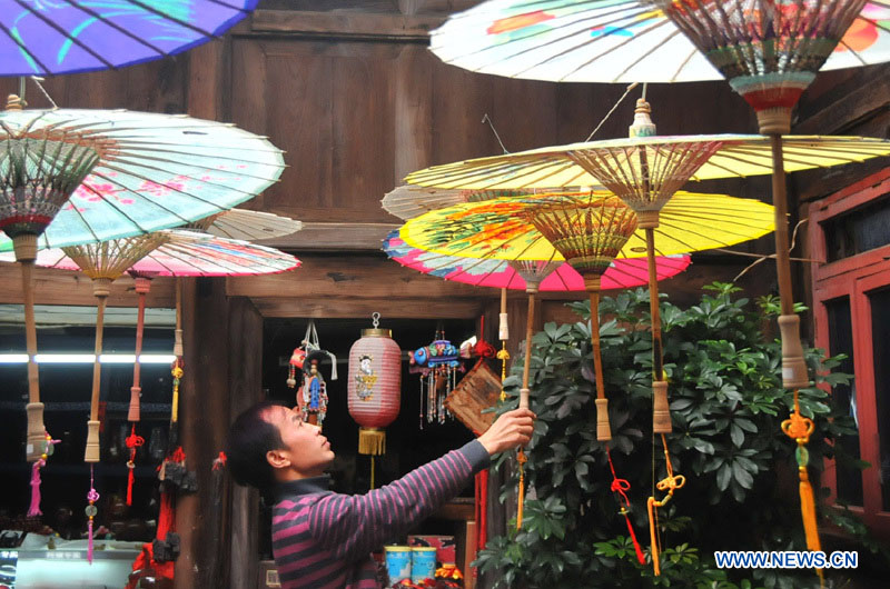 Un artisan regarde des parapluies de papier huilé dans un atelier du district de Xixiu, à Anshun, ville de la province du Guizhou (sud-ouest), le 12 novembre 2012. Fabriqué en papier huilé et doté d'une armature en bambou, ce type de parapluie est un objet artisanal traditionnel chinois. Les techniques de fabrication du parapluie de papier huilé ont été introduites au Guizhou durant la dynastie Ming. (Photo : Huang Yong)