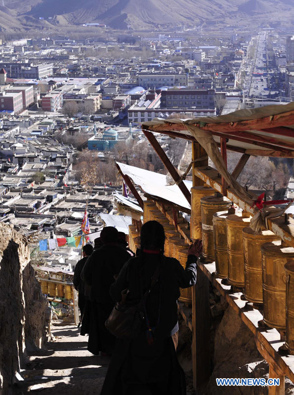 Des Tibétains marchent sur le chemin des moulins à prière du monastère de Tashilhunpo, le siège traditionnel des Panchen Lamas, à Xigaze, dans la région autonome du Tibet (sud-ouest), le 16 novembre 2012. Xigaze est la deuxième plus grande ville du Tibet.