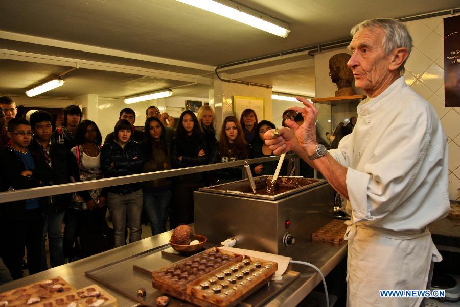 Un employé présente la confection de chocolats au Musée du cacao et du chocolat de Bruxelles, à l'occasion de la semaine du chocolat organisée dans la capitale belge, le 21 novembre 2012. (Photo : Yan Ting)