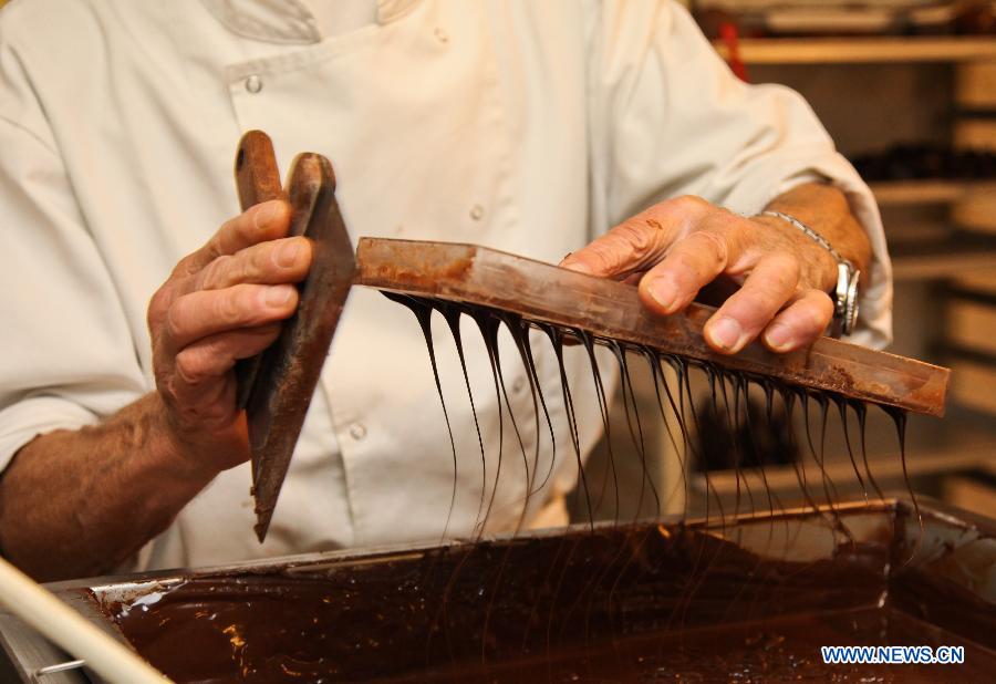 Un employé présente la confection de chocolats au Musée du cacao et du chocolat de Bruxelles, à l'occasion de la semaine du chocolat organisée dans la capitale belge, le 21 novembre 2012. (Photo : Yan Ting) 