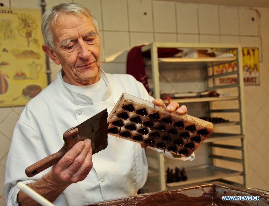 Un employé présente la confection de chocolats au Musée du cacao et du chocolat de Bruxelles, à l'occasion de la semaine du chocolat organisée dans la capitale belge, le 21 novembre 2012. (Photo : Yan Ting)