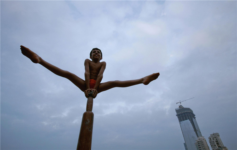 Un gar?on effectue un poser de mallakhamb sur un poteau, au Mandir Shree Samartha Vyayam à Bombay, le 21 octobre 2012. Le mallakhamb est un sport traditionnel indien qui est né comme un exercice complémentaire à la lutte, mais il est maintenant pratiqué comme un sport à part entière.