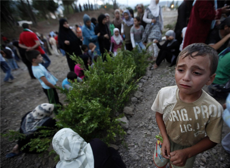 Un jeune réfugié syrien en pleurs lors des funérailles de cinq combattants de l'Armée Libre Syrienne, tués par les forces de sécurité syriennes près de la Province syrienne d'Idlib, dans la Province de Hatay Yayladagi, près de la frontière turco-syrienne, le 4 ao?t 2012.