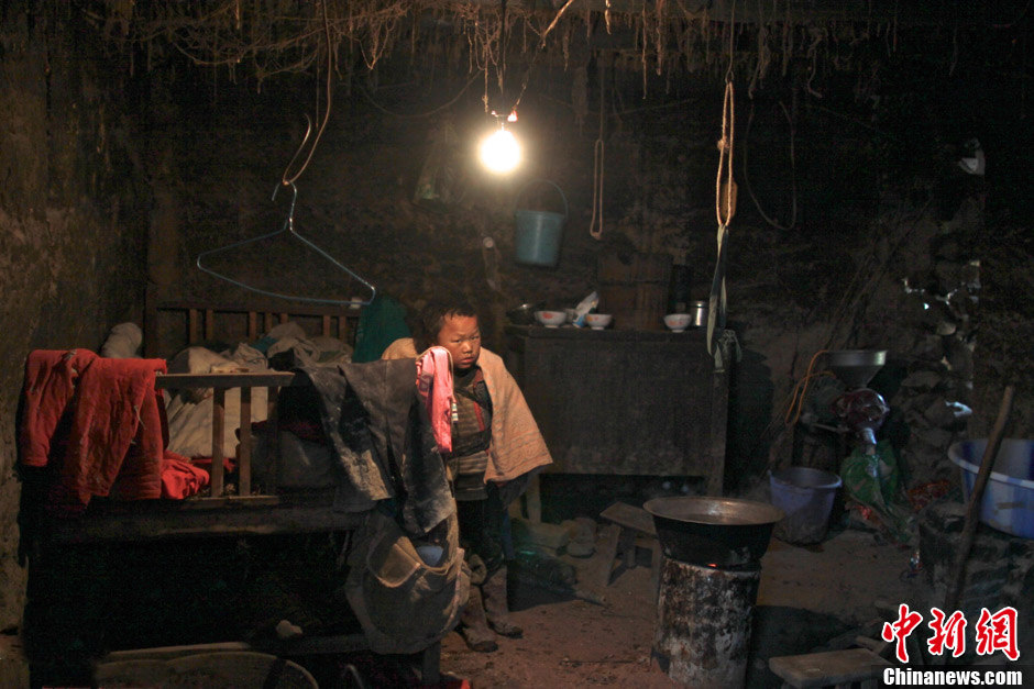 Un gar?on portant son petit frère au dos essaie de se cacher à la vue des inconnus. (Chinanews/Feng Zhonghao)