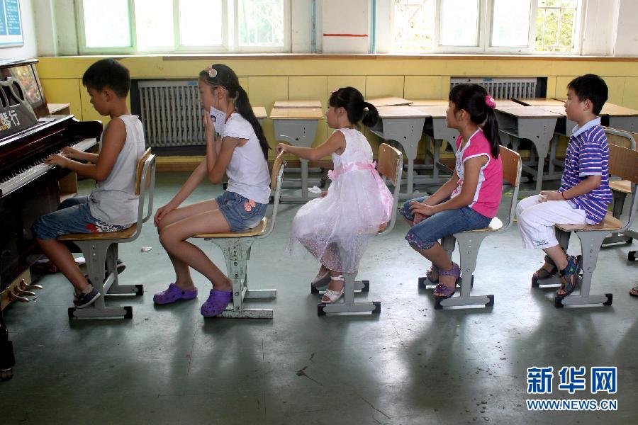 A Hefei, dans la province de l'Anhui, plusieurs enfants font la queue pour pratiquer le piano avant leur examen, le 4 ao?t 2012.