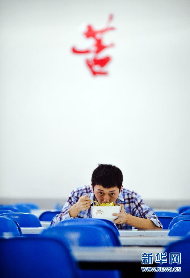 A Changsha, capitale de la province du Hunan, un lycéen prend son déjeuner dans la salle de classe le 24 mai 2012. Il a décidé de rester au lycée pour une année de plus afin de pouvoir être admis par une meilleure université. Bien que le Gaokao (concours national d'entrée à l'université) ne soit pas la seule fa?on de réussir en Chine, la plupart des jeunes Chinois espèrent changer leur destin grace à cette précieuse opportunité.