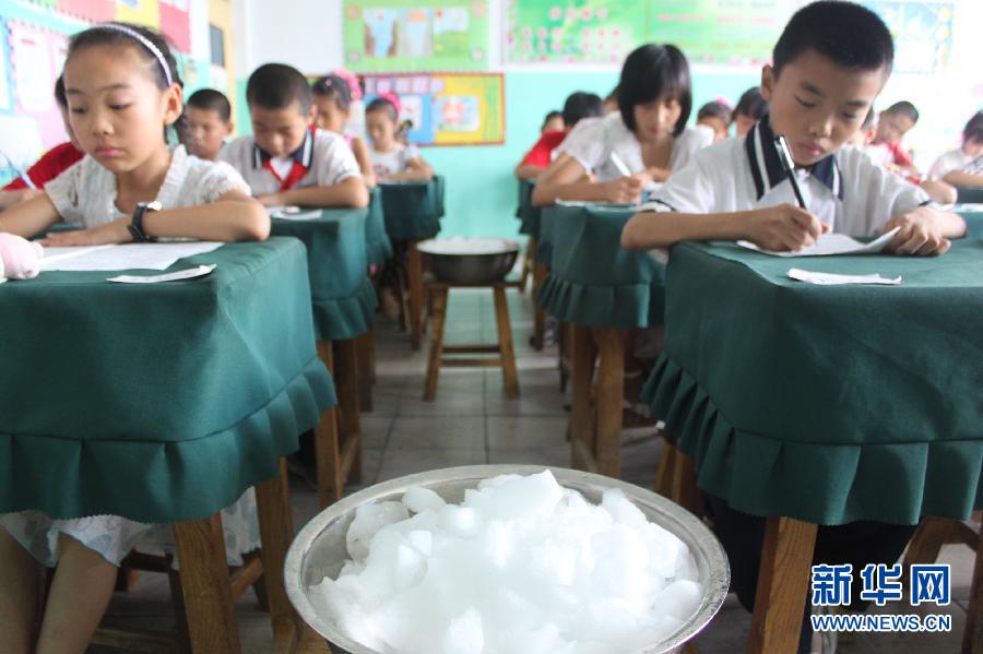 Dans une salle de classe d'une école primaire à Binzhou, dans la province du Shandong, des gla?ons ont été offerts à des écoliers du primaire qui passaient leur examen final le 3 juillet 2012. La température la plus élevée de ce jour-là a atteint 35 ℃.