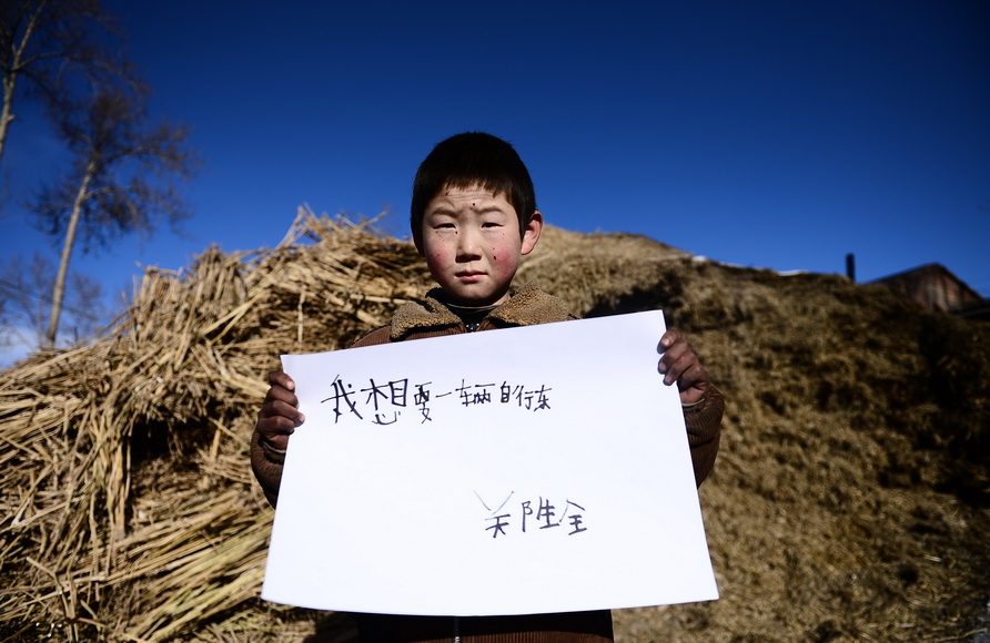 ? Je veux un vélo ?. C'est le voeu de Zheng Shengquan, agé de 9 ans et élève en 3e année de l'école primaire. Lui est sa grande soeur Zheng Shengxiu, sont à la charge de leurs grands-parents. ? Je veux une bicyclette pour aller voir mes parents. ?(Xinhua/Zhang Hongxiang)