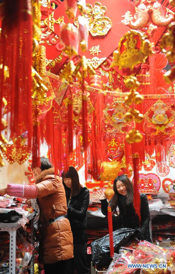 Des gens font des achats dans un marché à Zhengzhou, capitale de la province du Henan (centre de la Chine). Des gens achètent des décorations diverses pour accueillir la Fête du printemps à venir.