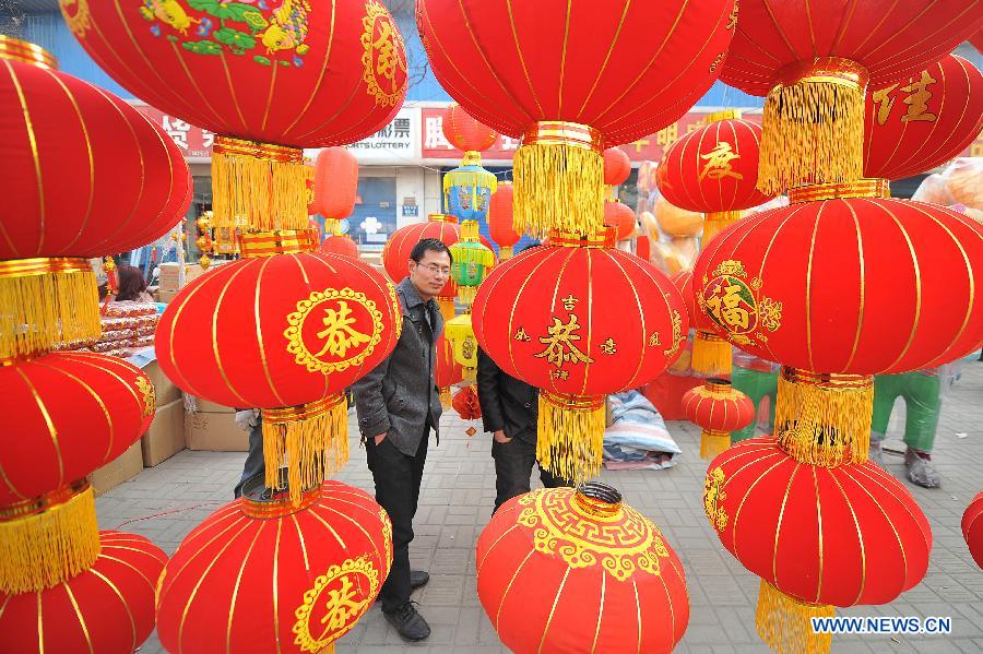 Des gens font des achats dans un marché à Zhengzhou, capitale de la province du Henan (centre de la Chine). Des gens achètent des décorations diverses pour accueillir la Fête du printemps à venir.