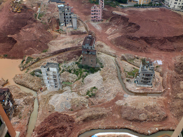 Plusieurs batiments d’habitation ont été isolés par des tranchées sur un chantier de construction dans le village de Yangqi, dans la ville de Guangzhou, capitale de la Province du Guangdong, dans le sud de la Chine, le 6 février 2013. Six ou sept familles vivent encore à l'intérieur, refusant de partir du fait de l'indemnité de relogement qu’elles jugent insuffisante, à la différence des autres villageois qui ont signé les accords de réinstallation et attendent la reprise de la construction, qui a été suspendue pendant plus de deux ans. Pour contraindre ces habitants récalcitrants à partir, d’autres habitants ont creusé des fossés autour des batiments. 