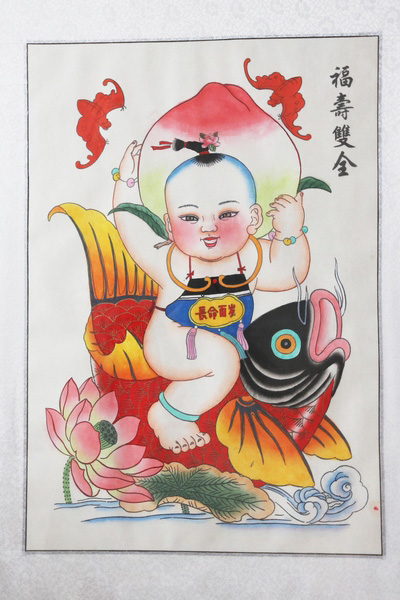 Les Nianhua, les peintures du Nouvel An lunaire, de l'atelier Yongshunhao du comté de Huaxian, contenant des images d'un poisson, d’un gar?on, de deux chauves-souris, une pêche et une fleur de lotus. La peinture reflète la volonté du peuple de pouvoir jouir du bonheur, de la richesse et la longévité de la vie. Photos : Bi xingshi/China Daily