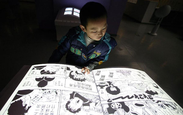 Un enfant lit une bande dessinée digitale dans un centre expérimental de dessins animés au Musée des sciences et technologies de Nanjing, capitale de la province du Jiangsu (est de la Chine). Le centre d'une superficie de 2700 mètres carrés a commencé ses premiers test, jeudi dernier, offrant un lieu culte pour les fans, leur permettant de mieux conna?tre l’industrie et la culture des dessins animés. [Photo/Xinhua]