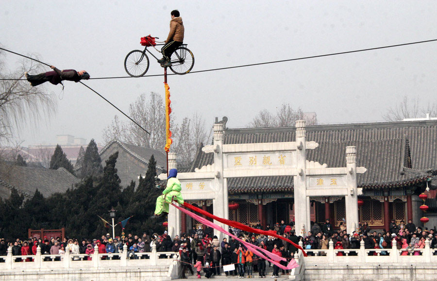 Des tours d'acrobatie donnés dans une foire du temple dans le Jardin de la Grandeur, à Beijing, le 13 février 2013. [Photo Huang Xiaobing / China Daily]