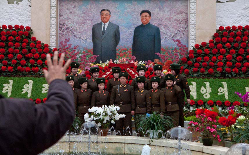 Durant l'Exposition de Fleurs Kim Jong-il, un photographe prend en photo des soldats devant les portraits de Kim Il-sung et de Kim Jong-il.