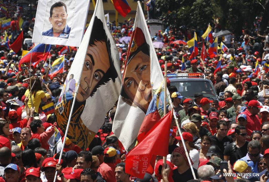 Le 6 mars 2013 dans les rues de Caracas, capitale vénézuélienne, des habitants accompagnent le cortège funéraire de leur défunt président Hugo Chavez. (Xinhua/AVN)