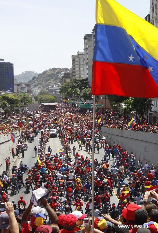 Le 6 mars 2013 à Caracas, capitale vénézuélienne, des membres de la Garde nationale vénézuélienne forment une barrière de sécurité pour contenir la foule des deux c?tés du cortège funéraire de leur défunt président Hugo Chvez. (Xinhua/Juan Carlos Hernandez)