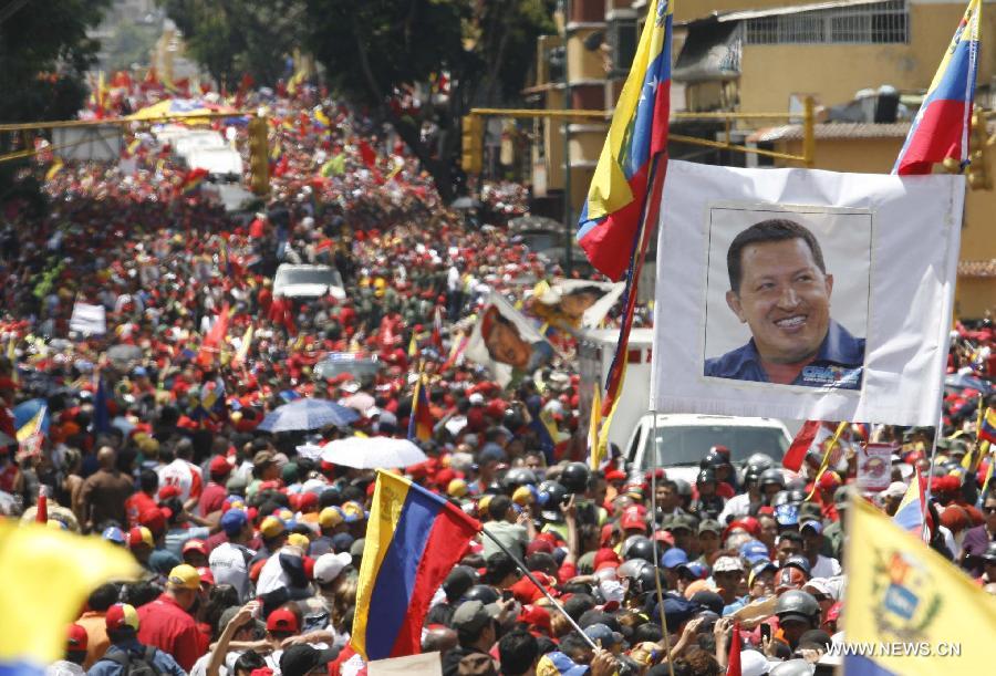 Le 6 mars 2013 à Caracas, capitale vénézuélienne, des membres de la Garde nationale vénézuélienne forment une barrière de sécurité pour contenir la foule des deux c?tés du cortège funéraire de leur défunt président Hugo Chvez. (Xinhua/Juan Carlos Hernandez)