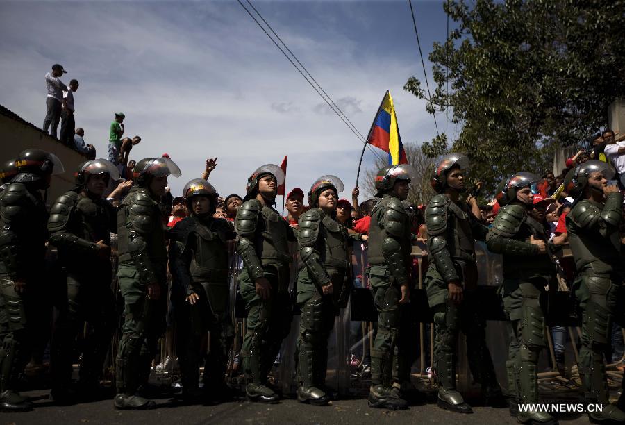 Le 6 mars 2013 à Caracas, capitale vénézuélienne, des membres de la Garde nationale vénézuélienne forment une barrière de sécurité pour contenir la foule des deux c?tés du cortège funéraire de leur défunt président Hugo Chvez. (Xinhua/Juan Carlos Hernandez)