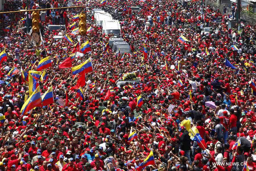 Le 6 mars 2013 dans les rues de Caracas, capitale vénézuélienne, des habitants accompagnent le cortège funéraire de leur défunt président Hugo Chavez. (Xinhua/AVN)