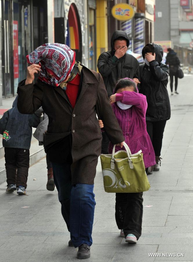 Des piétons affrontent des rafales de vent à Beijing, la capitale chinoise balayée samedi par une tempête de sable, le 9 mars 2013. (Photo : Li Wen)