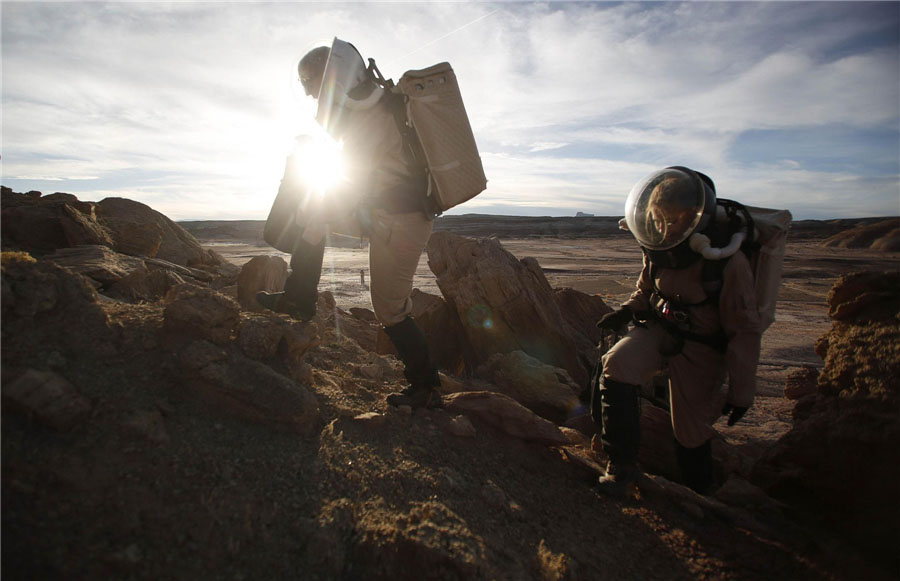 Melissa Battler (à gauche), géologiste et commandant de l'Equipe 125 de la mission EuroMoonMars B, et la géologiste Csilla Orgel, escaladent des rochers dans le désert de l'Etat d'Utah aux Etats-Unis le 2 mars 2013, pour collecter des échantillons géologiques destinés à des études menées par la Station Martienne de Recherche du Désert. [Photo/Agences]