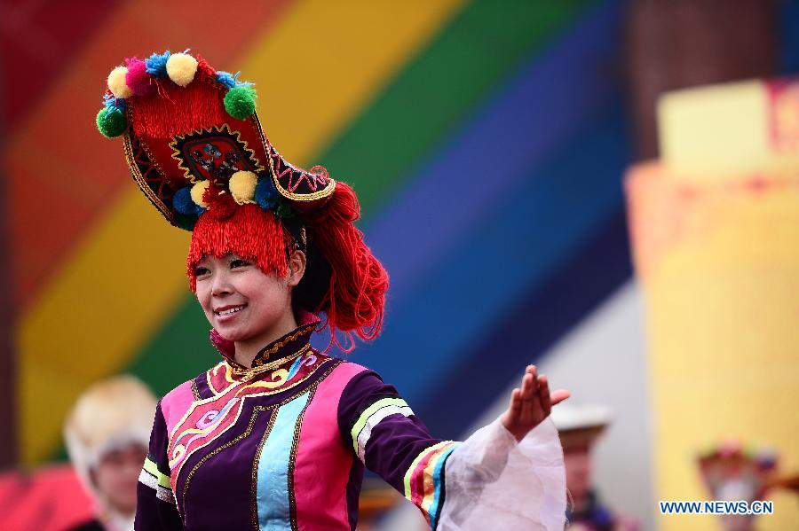 Une femme de l'ethnie Tu en costume traditionnel chante au cours des activités pour célébrer le Er Yue Er, le 13 mars 2013, dans le district autonome de l'ethnie Tu de Huzhu, dans la province du Qinghai, dans le Nord-ouest de la Chine. (Xinhua/Zhang Hongxiang)