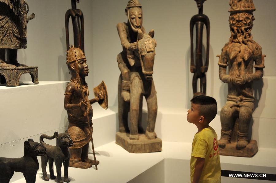 Un jeune gar?on regarde des sculptures africaines au Musée national de Chine à Beijing, le 31 mai 2012. Les échanges culturels et entre les peuples entre la Chine et les pays africains se sont développés au cours des dernières décennies, ce qui a renforcé la compréhension mutuelle et l'amitié traditionnelle entre les peuples. Le président chinois Xi Jinping se rendra en visite en Tanzanie, en Afrique du Sud et en République du Congo fin mars et assistera au 5ème Sommet des chefs d'Etat des BRICS les 26 et 27 mars à Durban, en Afrique du Sud. (Photo : Liu Changlong)