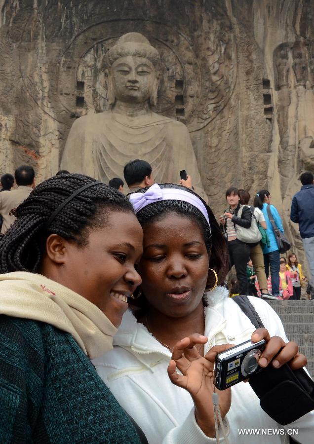 Des touristes africaines visitent les grottes de Longmen à Luoyang, dans la province du Henan (centre), le 11 avril 2012. Les échanges culturels et entre les peuples entre la Chine et les pays africains se sont développés au cours des dernières décennies, ce qui a renforcé la compréhension mutuelle et l'amitié traditionnelle entre les peuples. Le président chinois Xi Jinping se rendra en visite en Tanzanie, en Afrique du Sud et en République du Congo fin mars et assistera au 5e Sommet des chefs d'Etat des BRICS les 26 et 27 mars à Durban, en Afrique du Sud. (Photo : Wang Song)