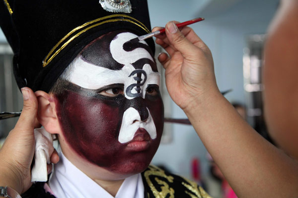 Chen Teng, élève d’une école primaire, se maquille pendant un cours d’Opéra de Puxian de la ville de Putian, dans la Province du Fujian, dans l'Est de la Chine, le 20 mars 2013. De nombreuses écoles primaires de Putian ont ouvert des cours d’Opéra de Puxian pour enrichir la vie scolaire et promouvoir la culture locale de la dynastie des Tang (618-907). Cet opéra a été classé comme patrimoine culturel immatériel national en 2006. [Photo / Xinhua]