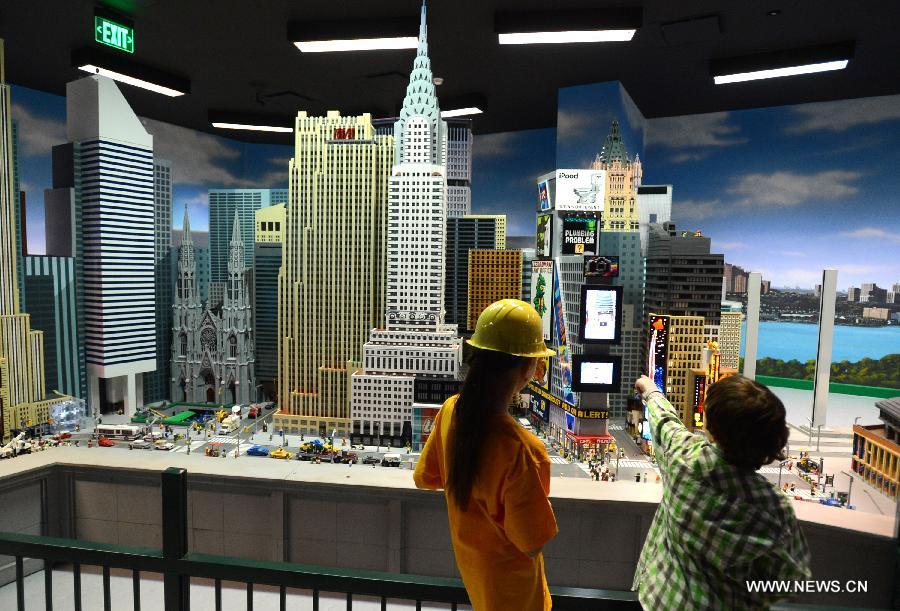 Des visiteurs admirent les modèles réduits des lieux célèbres de Manhattan fabriqués avec près d'un million de briques Lego, au parc Legoland Discovery Center de Westchester, à New York, aux Etats-Unis, le 21 mars 2013. Ce parc flambant neuf ouvrira ses portes le 27 mars. (Photo : Niu Xiaolei)