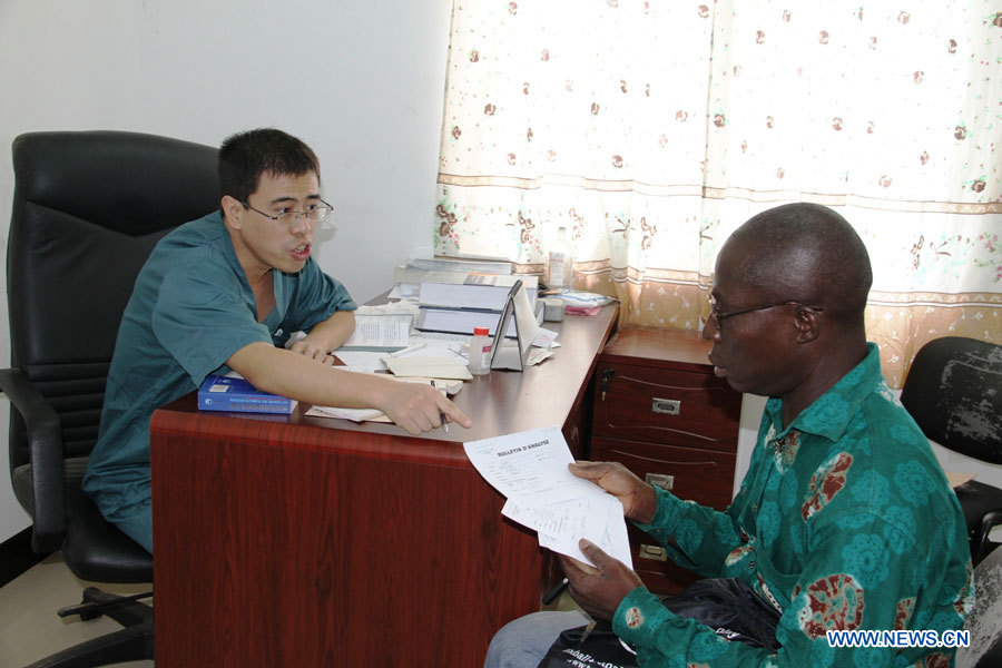 Chang Peng, médecin de l'équipe médicale chinoise, re?oit un patient dans un h?pital construit avec l'aide de la Chine, à Lomé, capitale du Togo, le 28 mars 2013. Le gouvernement chinois envoie des équipes médicales au Togo depuis 1974.