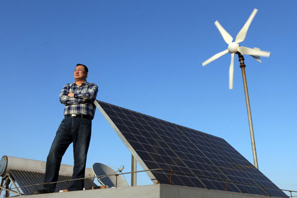 Dong Qiang à c?té d'un panneau du générateur d'électricité installé sur son toit à Tianjin, le 6 avril 2013.