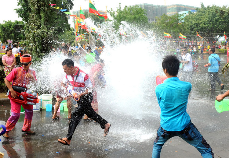 Les gens s'aspergent les uns les autres lors des célébrations de la Fête de l'eau dans la préfecture autonome Dai et Jingpo de Dehong, dans le Yunnan, le 11 avril 2013. [Photo / Xinhua]