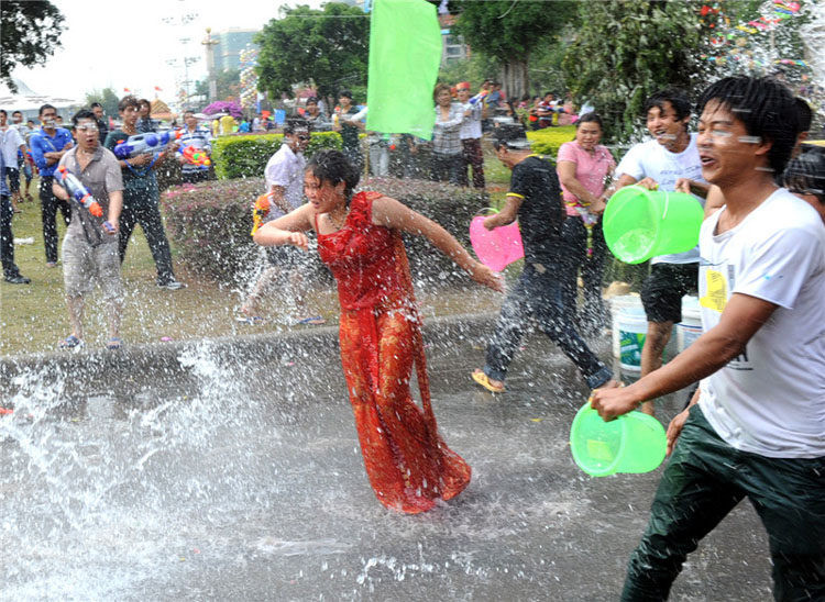 Les gens s'aspergent les uns les autres lors des célébrations de la Fête de l'eau dans la préfecture autonome Dai et Jingpo de Dehong, dans le Yunnan, le 11 avril 2013. [Photo / Xinhua]