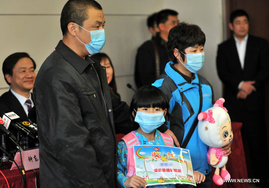 Yao, une fillette de sept ans qui a été le premier cas confirmé d'infection H7N9 dans la capitale de la Chine prend part à une conférence de presse, accompagnée par ses parents, à Beijing le 17 avril 2013. [Photo Wang Jing / Asianewsphoto]