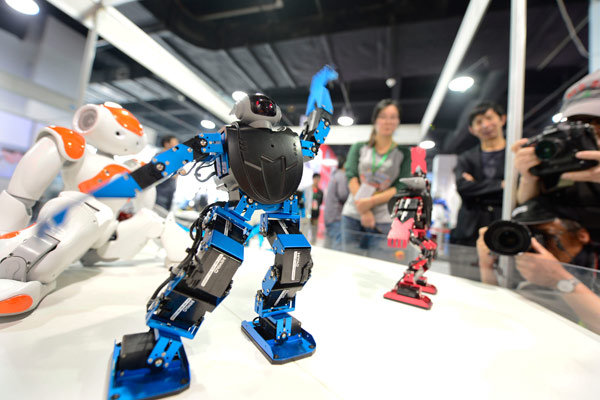 Jeudi, des visiteurs devant un robot dansant, lors d'une foire de l'électronique à Hangzhou, dans la province du Zhejiang [Photo / Asianewsphoto]