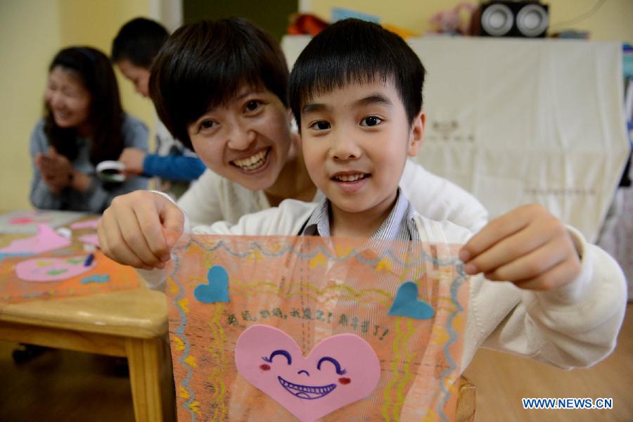 Le 9 mai 2013 dans une école maternelle à Hefei, capitale de la province chinoise de l'Anhui, un gar?on est fier de montrer le mouchoir qu'il a confectionné pour sa mère. (Photo : Xinhua/Zhang Duan)