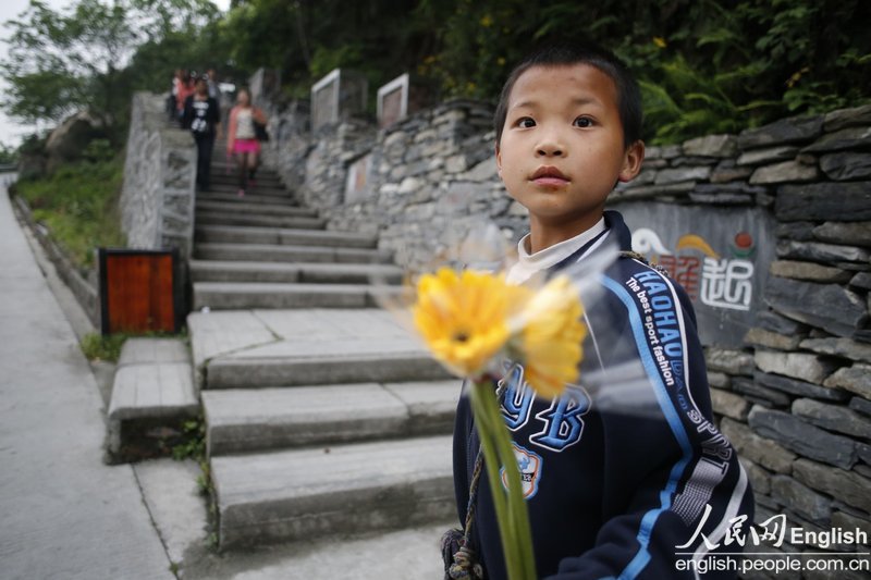 Un petit gar?on vend des chrysanthèmes en dehors du Musée commémoratif du séisme de Wenchuan le 29 avril 2013. (Photo : CFP)