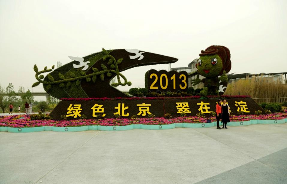 Les visiteurs prennent des photos devant une sculpture de fleurs illustrant le District de Haidian à Beijing lors de la neuvième Exposition Internationale d'Horticulture de Chine, qui se tient à Beijing, dans le District de Fengtai. L'exposition est prête pour son ouverture le 18 mai ; elle durera jusqu'au 18 novembre. [Photo par Michael Thai / China Daily]