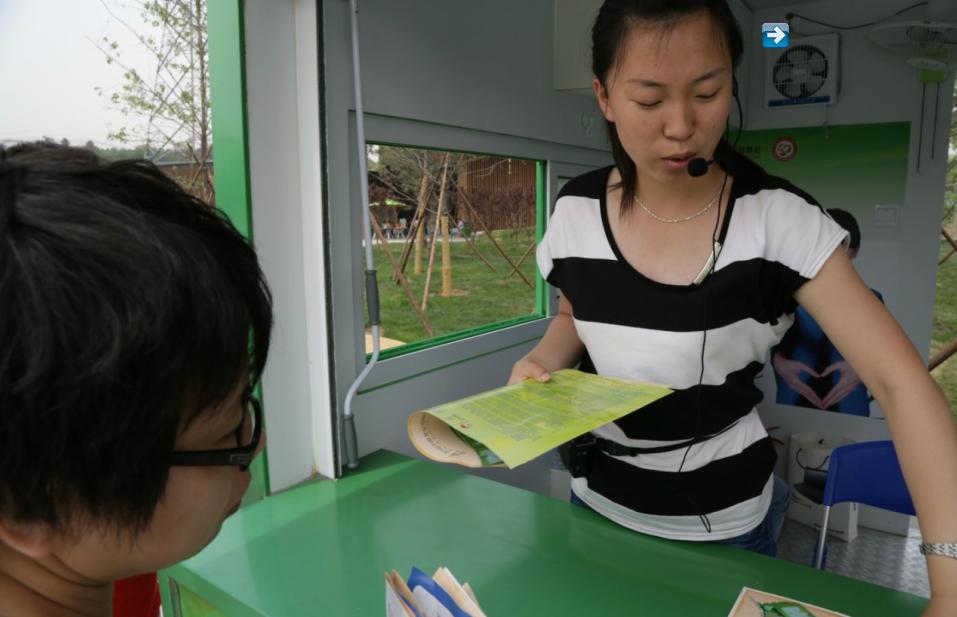 Un membre du personnel d'un centre de service de l'Expo Horticole indique à un visiteur le chemin vers l'arrêt de bus le plus proche. L'exposition est prête pour son ouverture le 18 mai ; elle durera jusqu'au 18 novembre. [Photo par Michael Thai / China Daily]