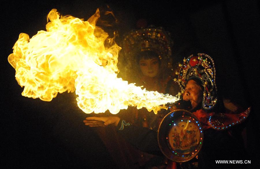 Sur cette photo d'archive, prise le 19 ao?t 2013 au Musée du Temple Wuhuo à Chengdu, capitale de la province du Sichuan, un cracheur de feu de l'opéra du Sichuan feu occupe la scène. (Xinhua/Xue Yubin)