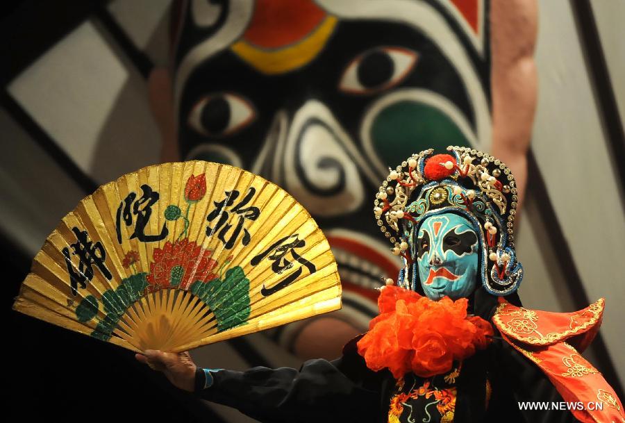 Sur cette photo d'archive, prise le 19 ao?t 2013 au Musée du Temple Wuhuo à Chengdu, la capitale de la province du Sichuan, un acteur de l'opéra du Sichuan opère un changement de masques sur scène. (Xinhua/Xue Yubin)