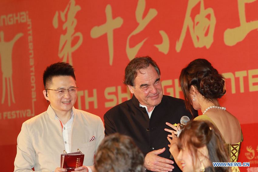 Le réalisateur américain Oliver Stone (centre) sur le tapis rouge de la cérémonie d'ouverture du 16e Festival international du film de Shanghai, le 15 juin 2013