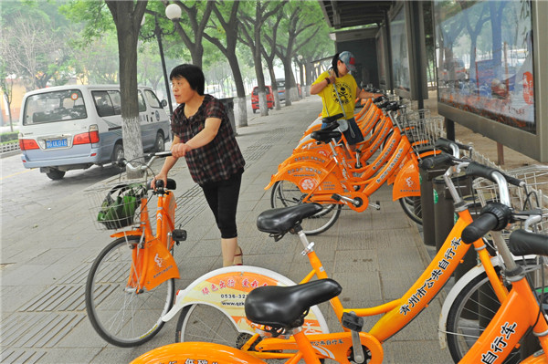 Des habitants louent des vélos publics pour rouler dans la ville de Qingzhou, dans la Province du Shandong, le 17 juin 2013. La Journée Nationale du Bas Carbone a eu lieu cette année le 17 juin 2013, sur le thème ? Ayez une attitude pauvre en carbone et construisez de belles maisons ?. [Photo Wang Jilin / Asianewsphoto]