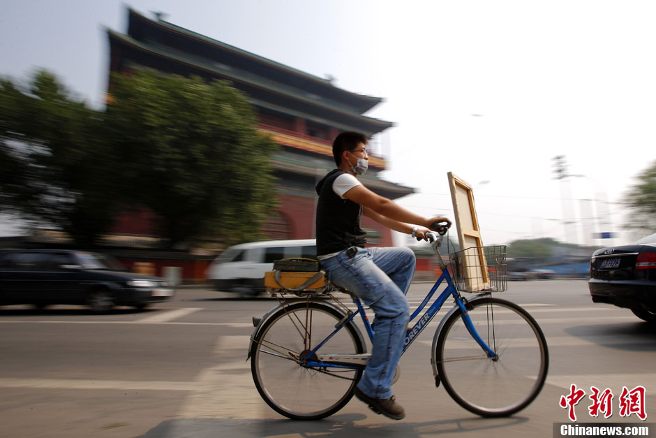 Fucha Danqing passe devant la tour du tambour à bicyclette. C'est l'endroit où il peint souvent. A bicyclette, il choisit souvent les endroits de ce coin pour réaliser ses ?uvres d'art.